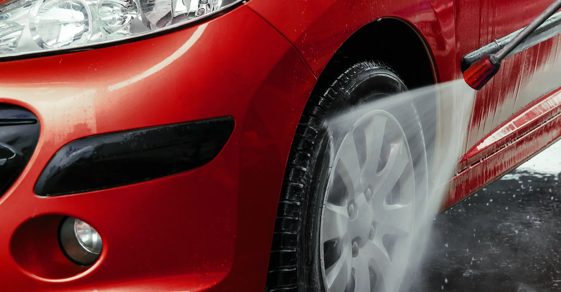 A red car receiving an exterior hand wash